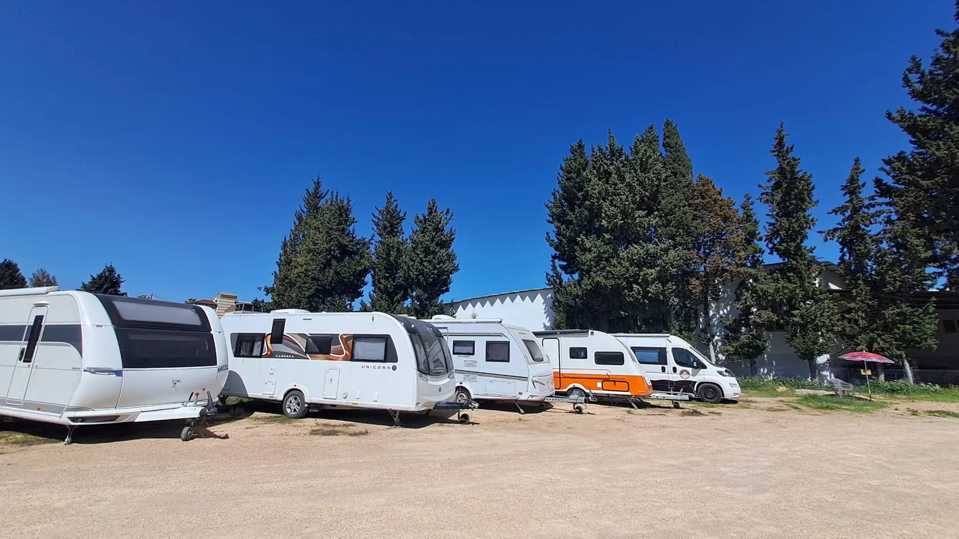Otopark alanında yan yana park etmiş karavanlar